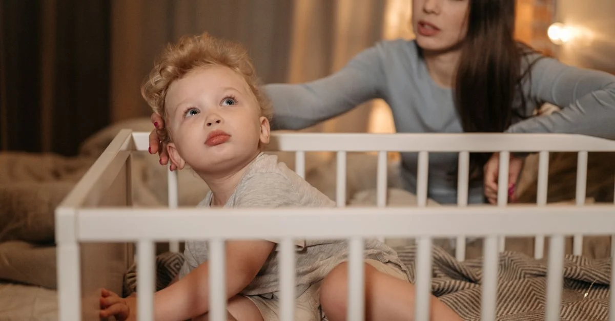 Mãe brincando com o filho mais velho enquanto o bebê está no berço