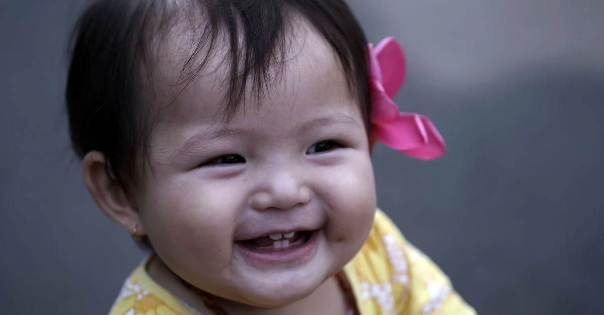 Bebê sorrindo com primeiros dentinhos