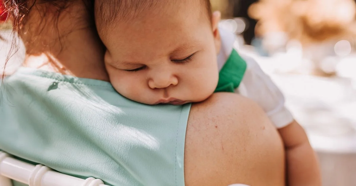 Mãe ajudando bebê a arrotar no ombro