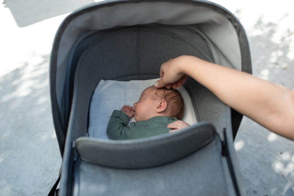 Recém-nascido em um carrinho de bebê sendo cuidado por um adulto ao ar livre.