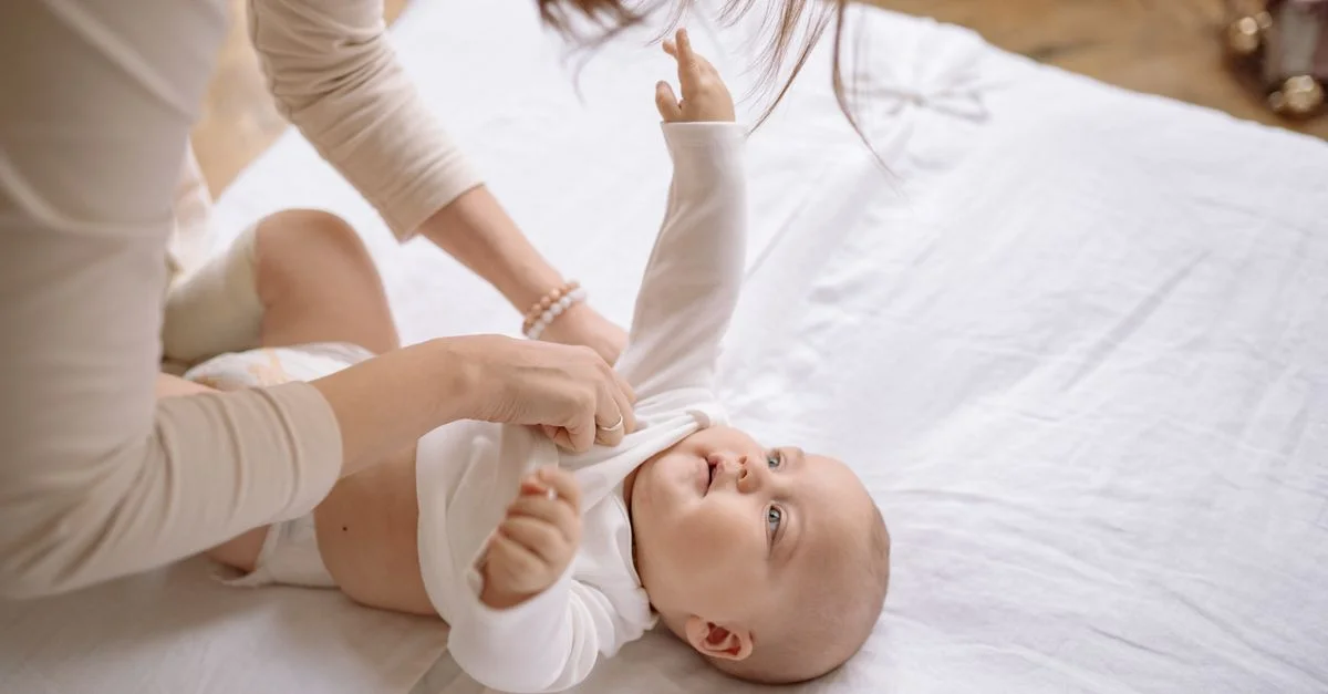 Mãe vestindo bebê com roupas adequadas para o frio