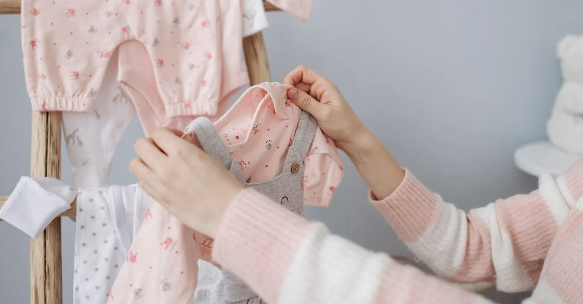Roupinhas de bebê menina dobradas em tons suaves