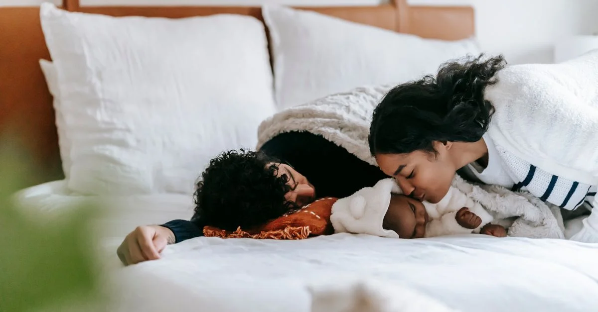 Casal e bebê aconchegados juntos na cama