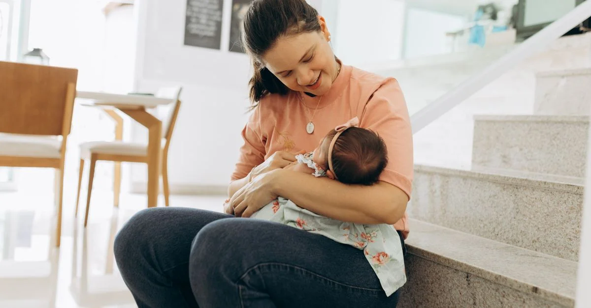 Mãe segurando o bebê recém-nascido no colo com carinho