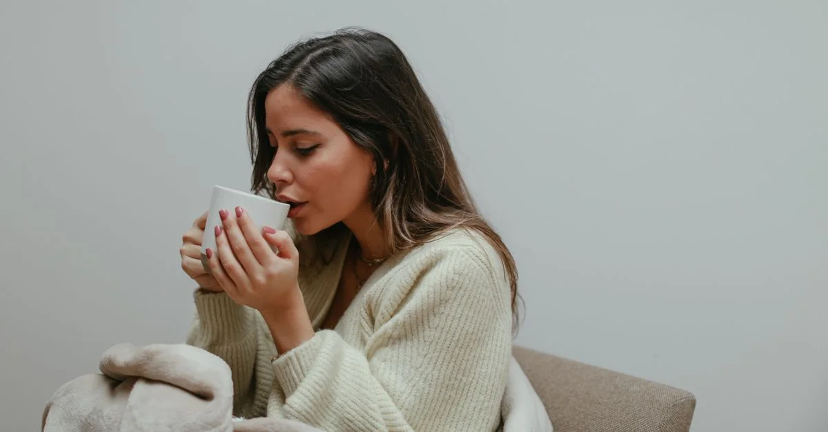 Mãe descansando no sofá com uma xícara quente nas mãos