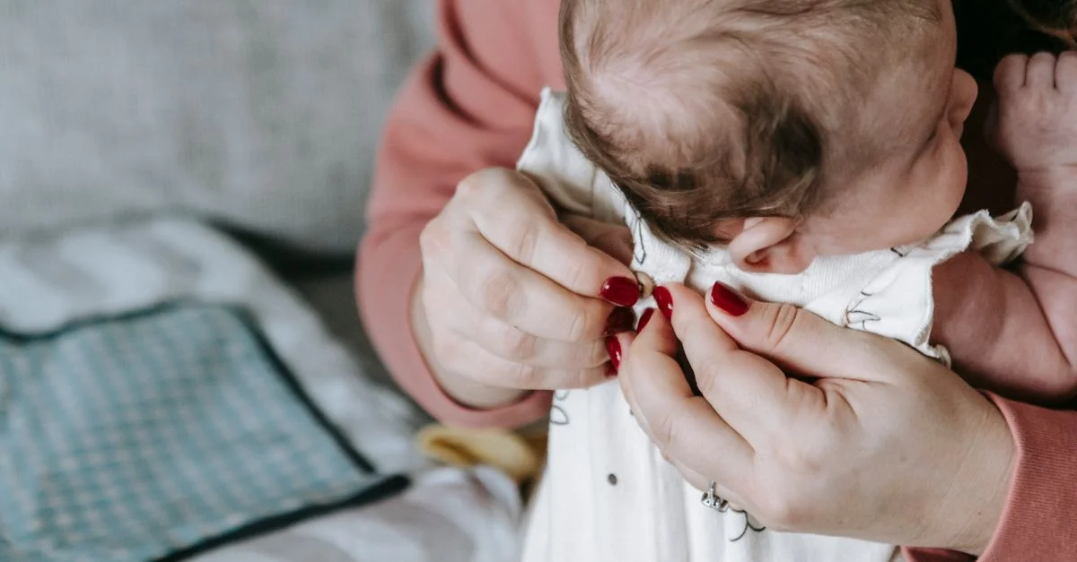Mãe aplicando pomada na pele do bebê