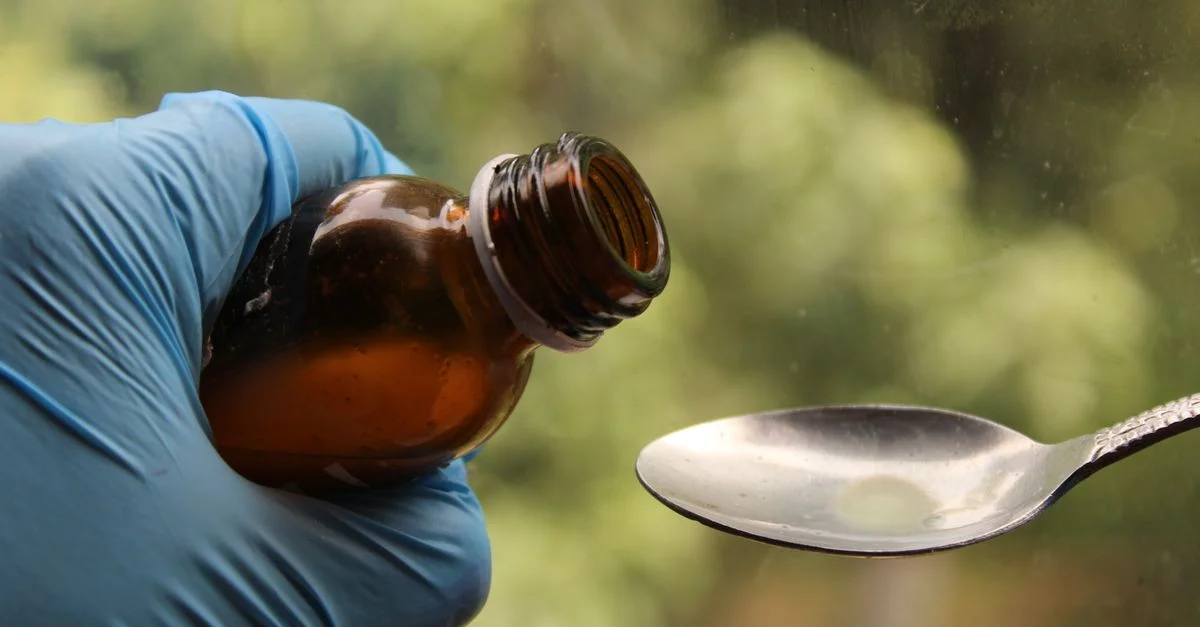Mãe calculando dose de medicamento para bebê