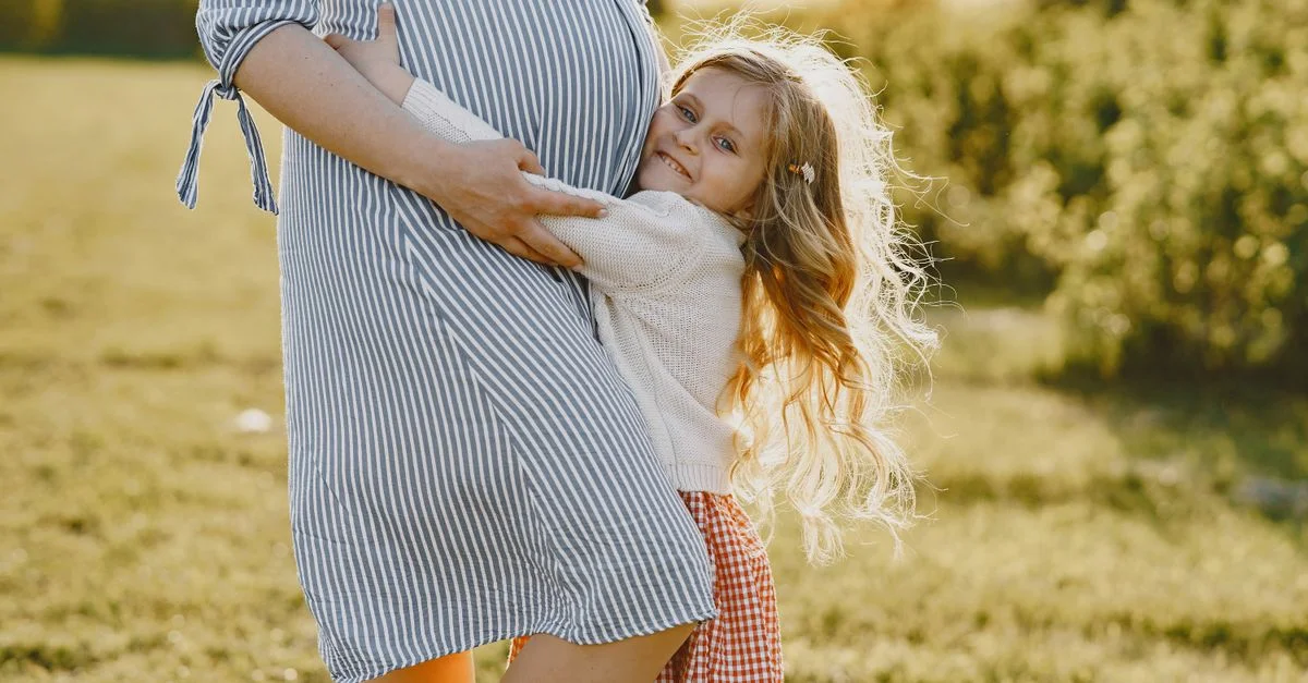 Mãe grávida abraçando o filho mais velho