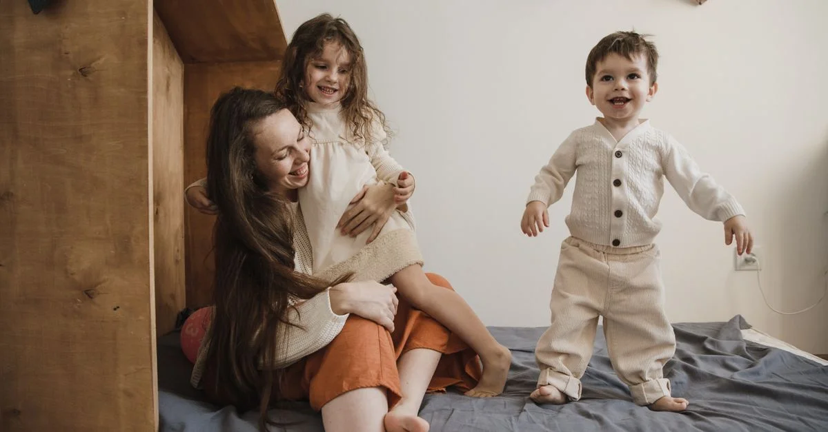 Mãe com dois filhos pequenos em casa